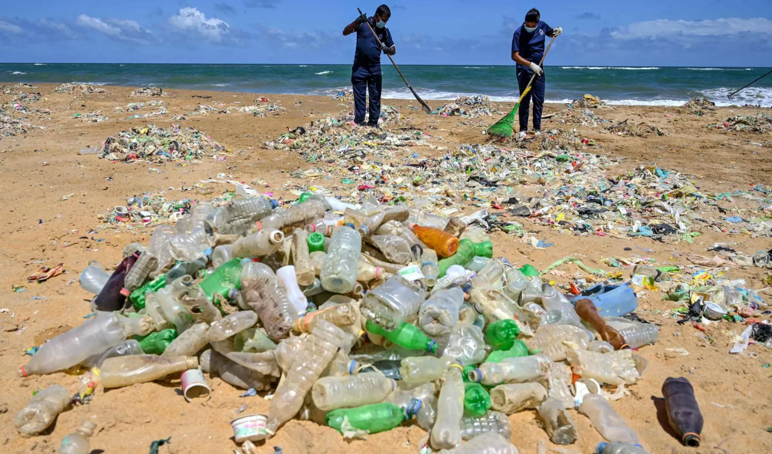 تنظيف أحد الشواطئ من النفايات وقناني البلاستيك الفارغة في كولومبو بسريلانكا (أ.ف.ب)