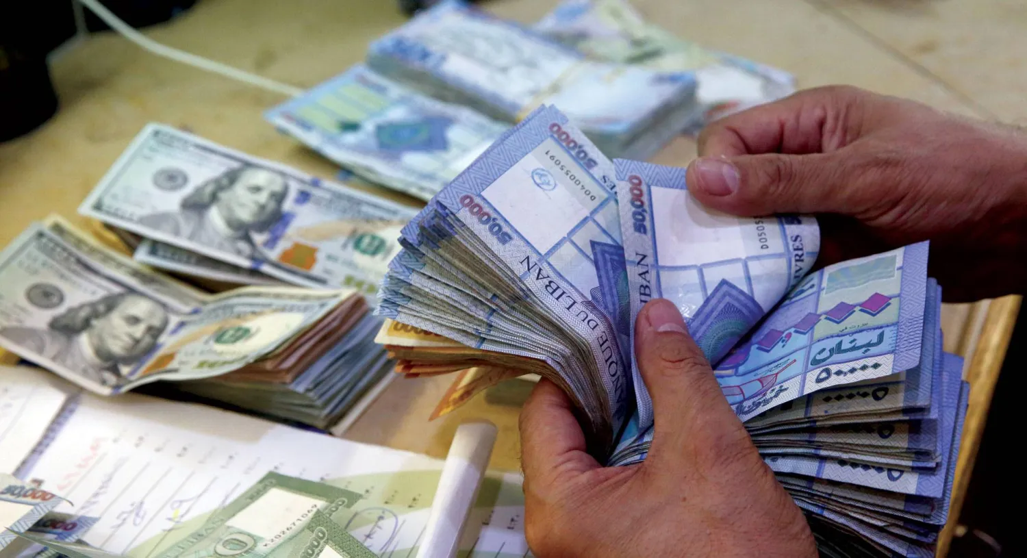 يسعى «مصرف لبنان» للحد من عمليات التبادل بالنقد الورقي لضبط عمليات تبييض الأموال (أ.ب)