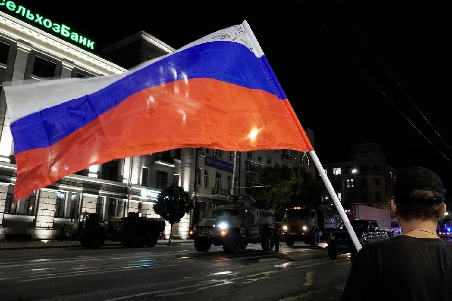 A man waves the Russian national flag as the members of Wagner group prepare to pull out from the headquarters of the Southern Military District to return to their base in Rostov-on-Don late on June 24, 2023. (AFP) 