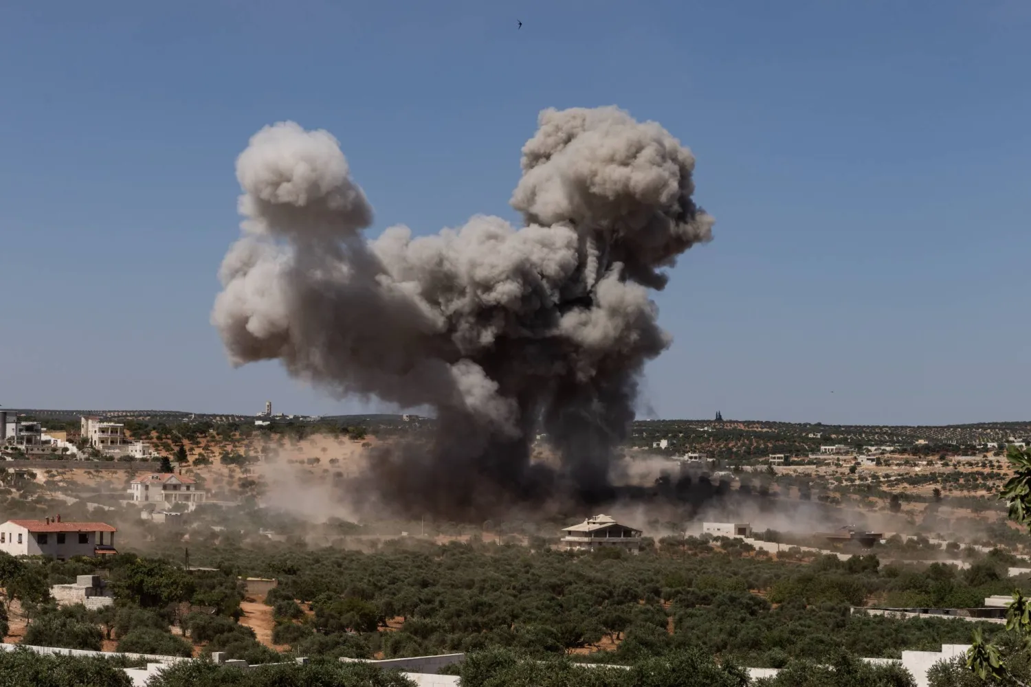 دخان الغارات يتصاعد فوق جسر الشغور نتيجة الغارات الروسية (د.ب.أ)