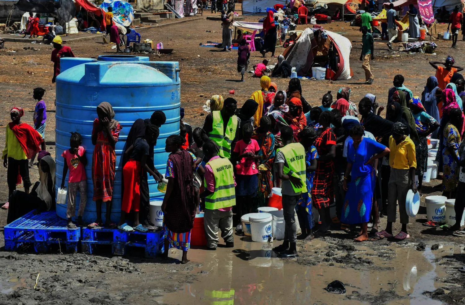 سودانيون يتجمعون حول خزان مياه تابع لمفوضية الأمم المتحدة لشؤون اللاجئين في منطقة الرنك بغرب السودان (رويترز)