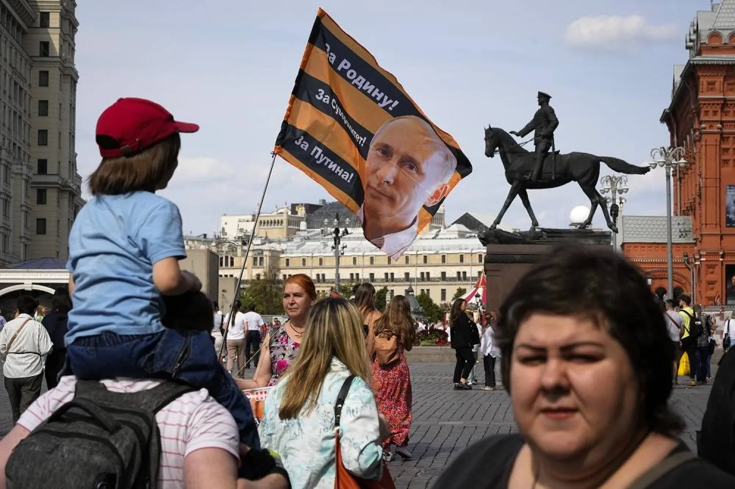 A pro-Kremlin activist holds a flag with an image of Russian President Vladimir Putting and the words in Russian "For the Motherland, for the sovereignty, for the Putin", near the Kremlin in Moscow, Russia, Sunday, June 25, 2023. (AP) 