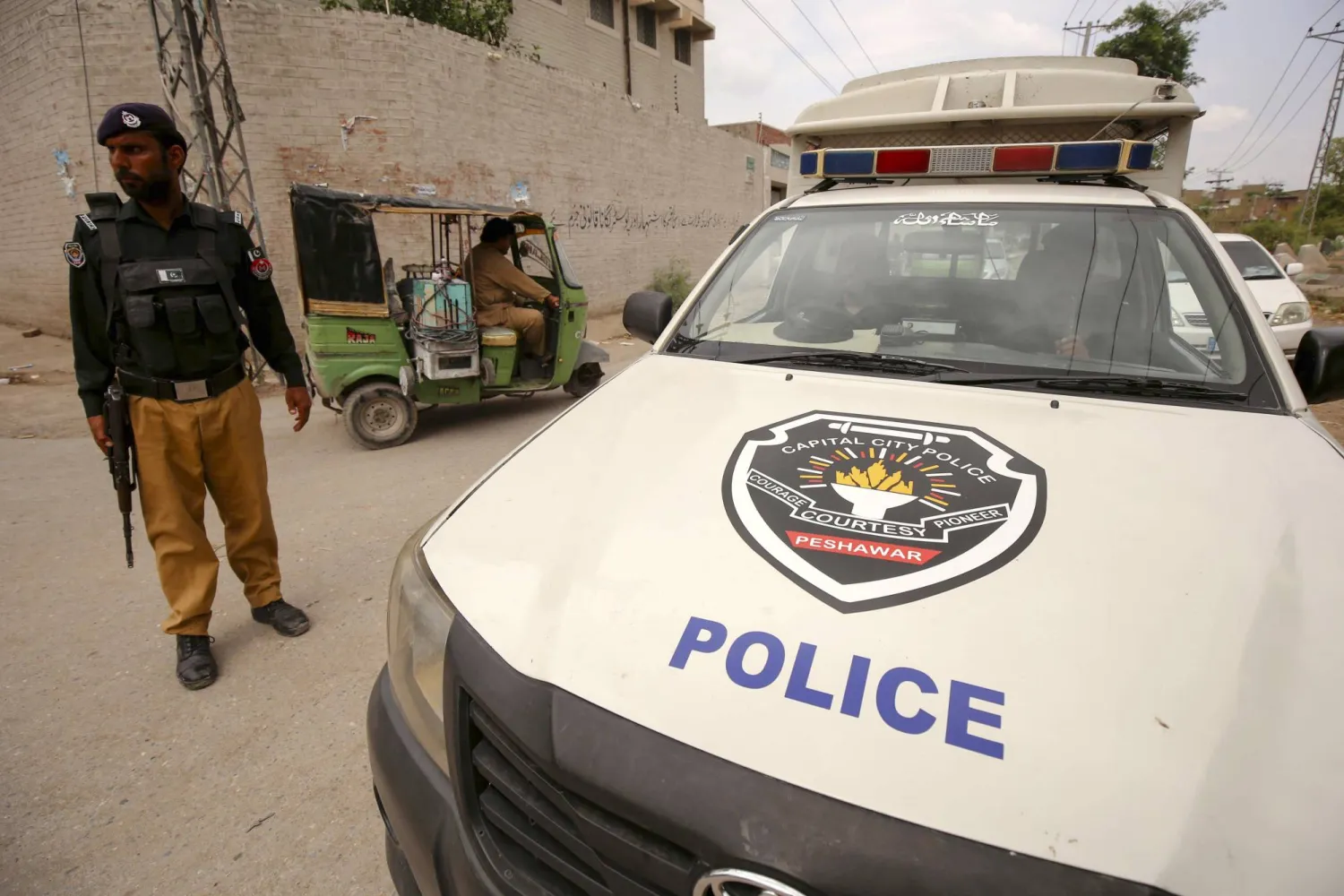  ضابط باكستاني يقف بجانب مركبة للشرطة أثناء قيامه بدورية حيث تم زيادة الأمن بعد مقتل تاجر سيخ على يد مسلحين مجهولين في بيشاور ، باكستان ، 26 يونيو 2023 " أ.ب.أ "