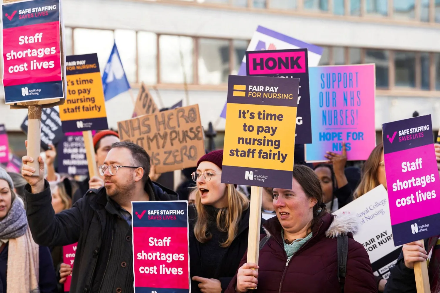 ممرضات من هيئة الخدمات الصحية الوطنية يحملن لافتات أثناء إضراب في ديسمبر2022 بشأن الأجور خارج مستشفى سانت توماس في لندن ببريطانيا (رويترز)