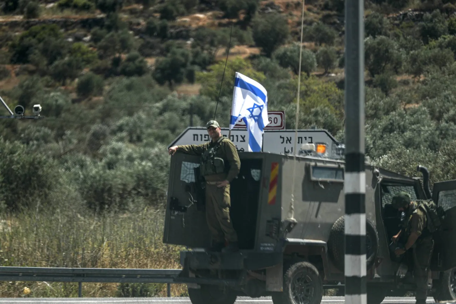 جنود إسرائيليون يحرسون مفترق طرق على طريق 60 بالقرب من مستوطنة في الضفة الغربية (إ.ب.أ)