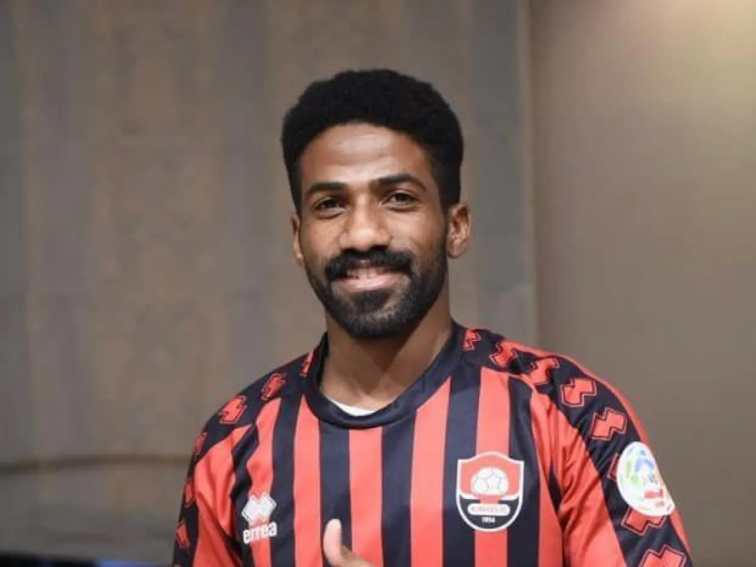 عوض خميس مرتدياً قميص الأخدود بعد توقيع العقد (الشرق الأوسط)