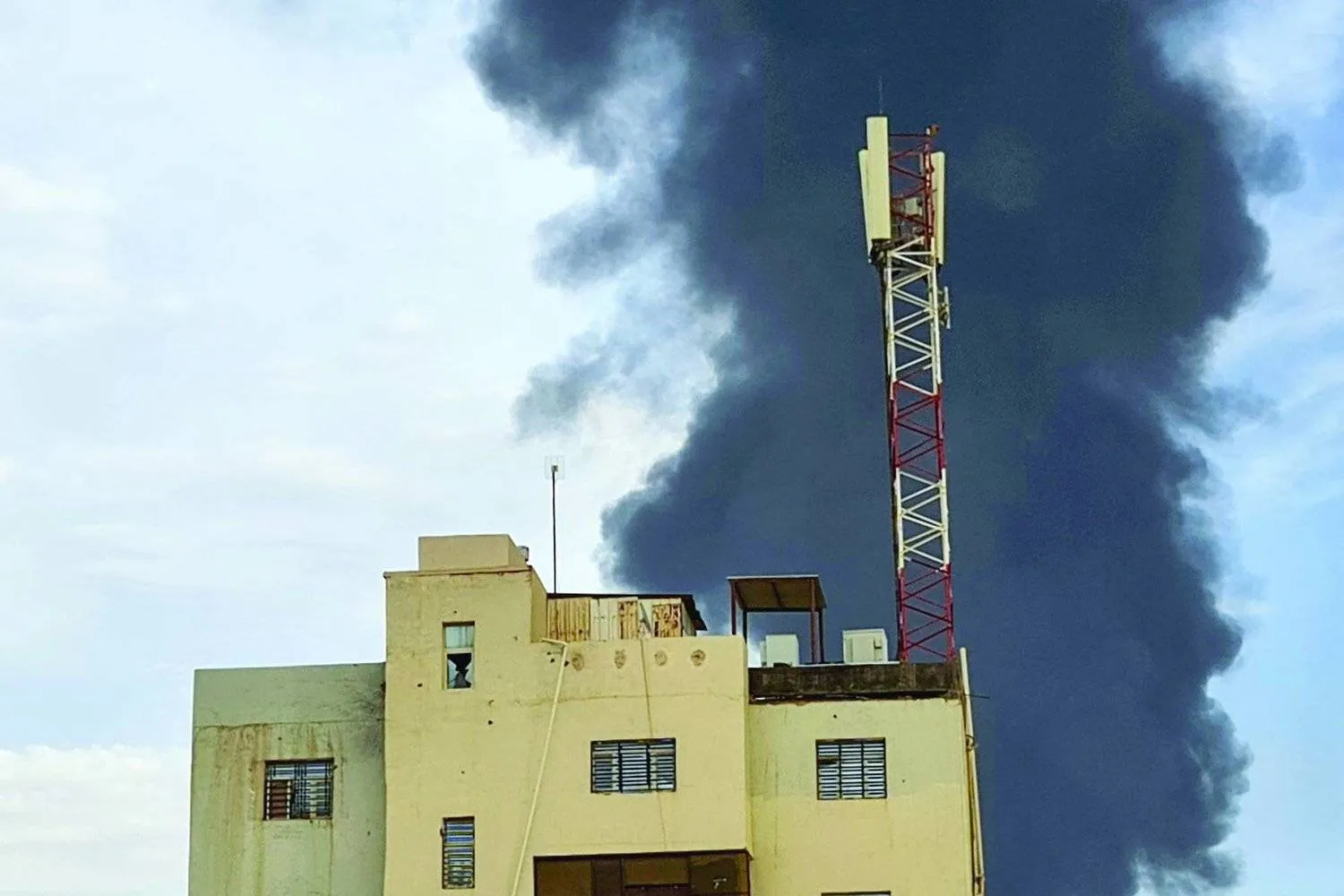 Smoke rises behind a building during clashes in southern Khartoum. (AFP)