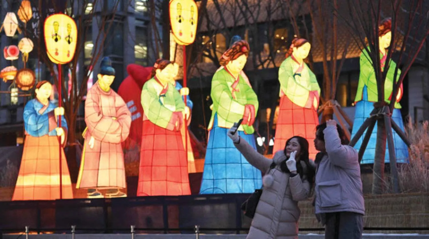 فتاتان تلتقطان صورة تذكارية وسط العاصمة الكورية الجنوبية سيول (أ.ف.ب)