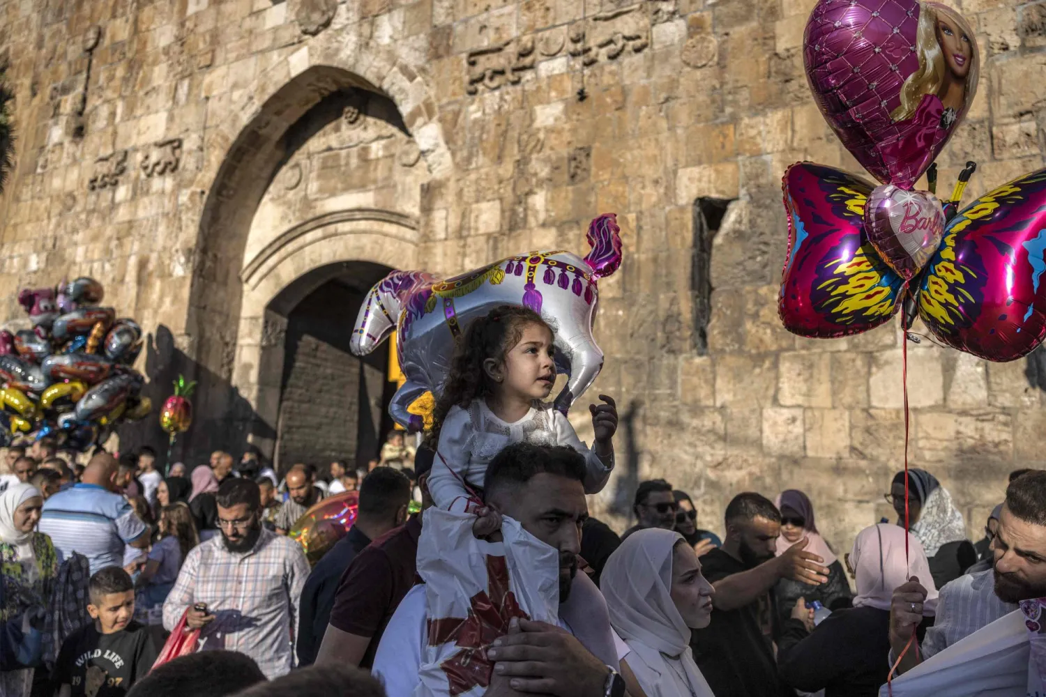 مصلون يتجمعون خارج باب الأسد في القدس القديمة المسورة بعد أداء صلاة عيد الأضحى الأربعاء (أ.ف.ب)