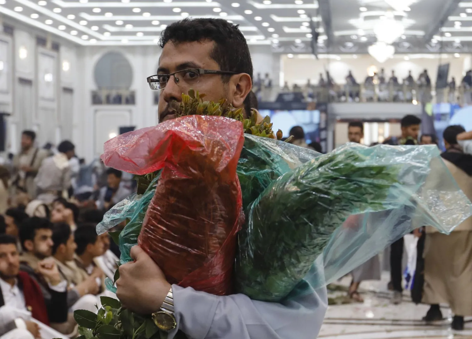 يمني في صنعاء يحمل حزماً من نبتة القات المخدرة (إ.ب.أ)