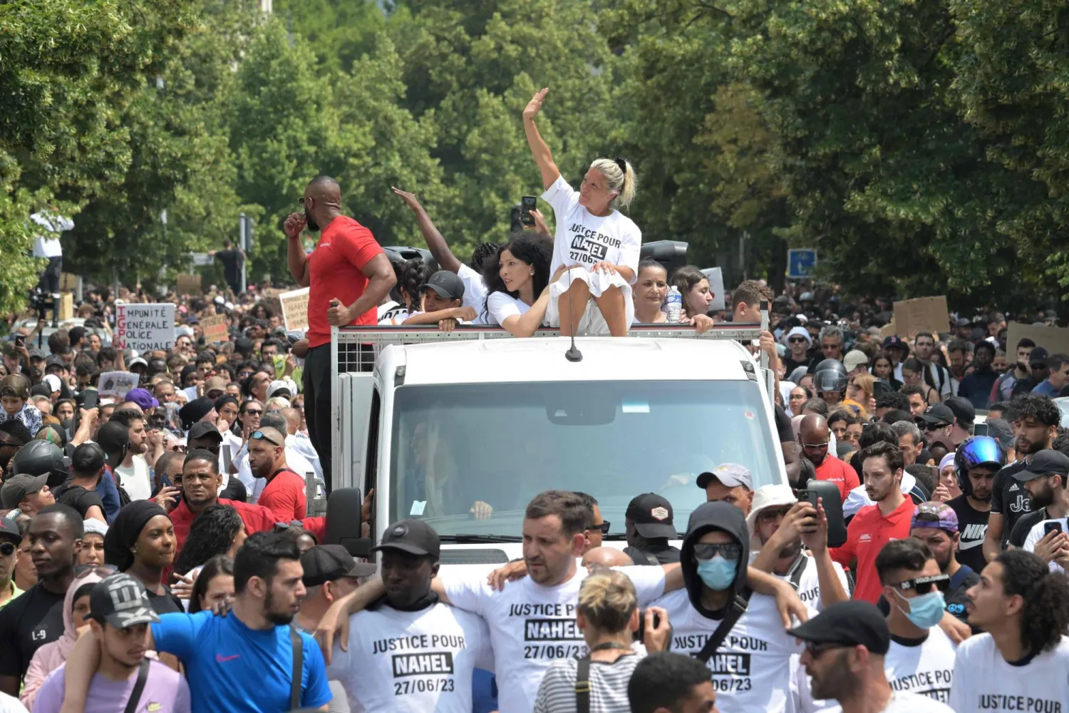 والدة الفتى الذي قتل برصاص الشرطة تلوح بيدها خلال مظاهرة احتجاجية في نانتير غرب باريس أمس (أ.ف.ب)