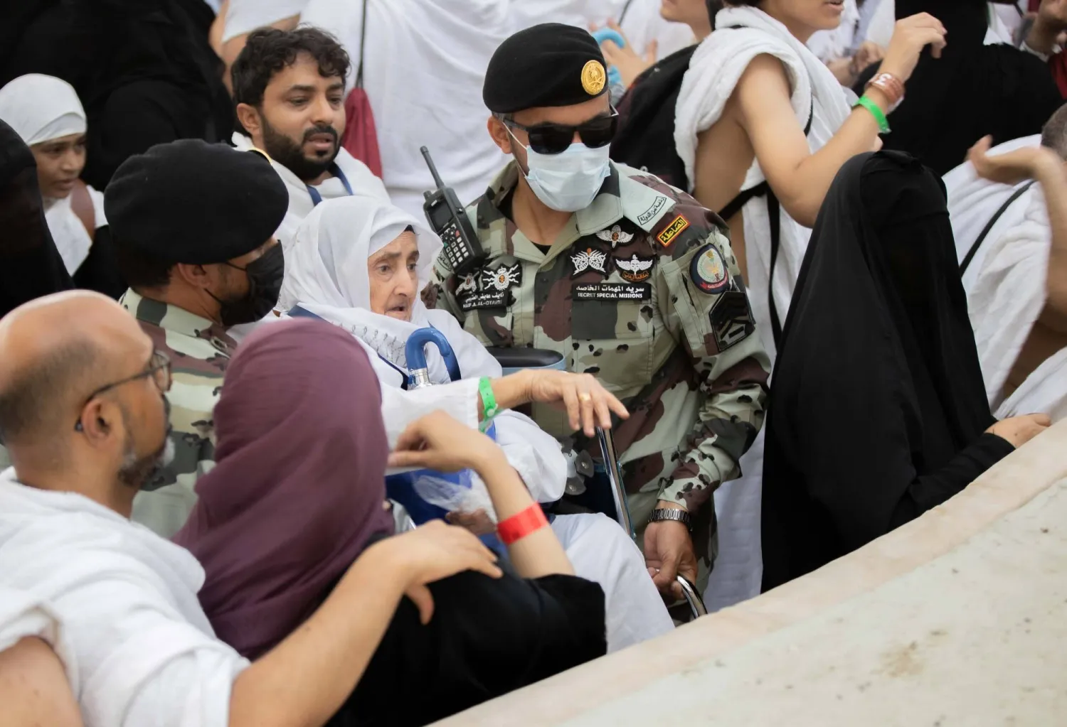 رجال أمن يساعدون حاجّة مسنّة في رمي الجمرات (عدنان مهدلي)