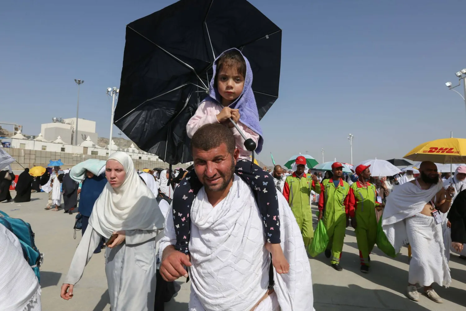 طفلة تحمي والدها من أشعة الشمس (عدنان مهدلي)