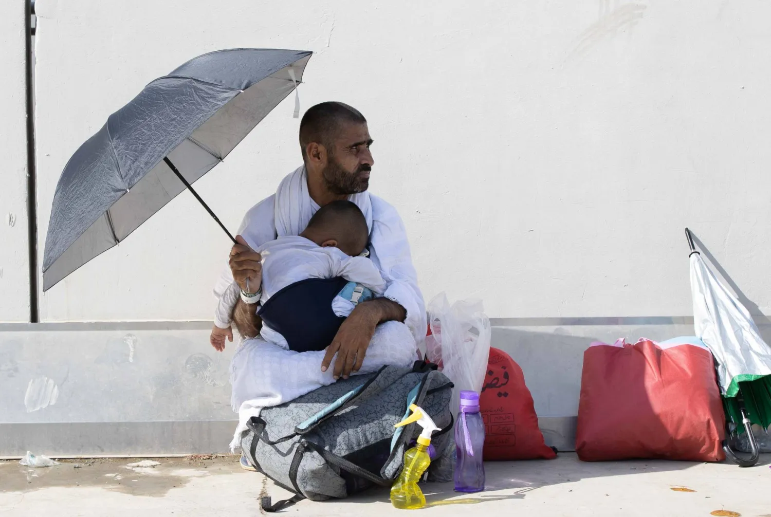 حاج يحتضن ابنه النائم بعد يوم طويل (عدنان مهدلي)