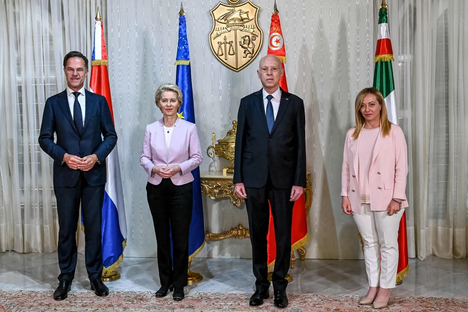 This handout picture provided by the Tunisian Presidency Press Service shows Tunisia's President Kais Saied (2nd-R) posing for a photo with the President of the European Commission Ursula von der Leyen (2nd-L), Italian Prime Minister Giorgia Meloni (R), and Dutch Prime Minister Mark Rutte (L) at Carthage Palace in Carthage on the eastern outskirts of the Tunisian capital on June 11, 2023. (AFP Photo / Handout / Presidency Press Service) 
