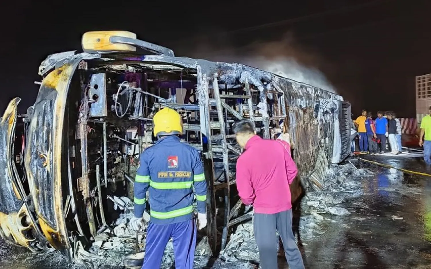 عمال الإنقاذ بالقرب من الحافلة المحترقة (وسائل إعلام هندية)