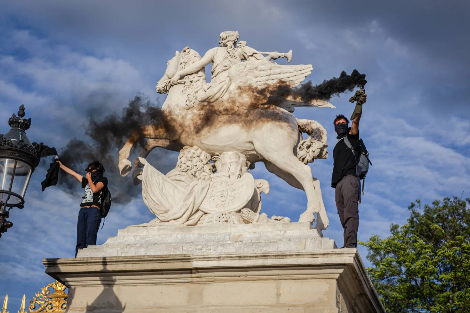 محتجون يحملون قنابل دخان خلال الاحتجاجات في فرنسا (د.ب.أ)