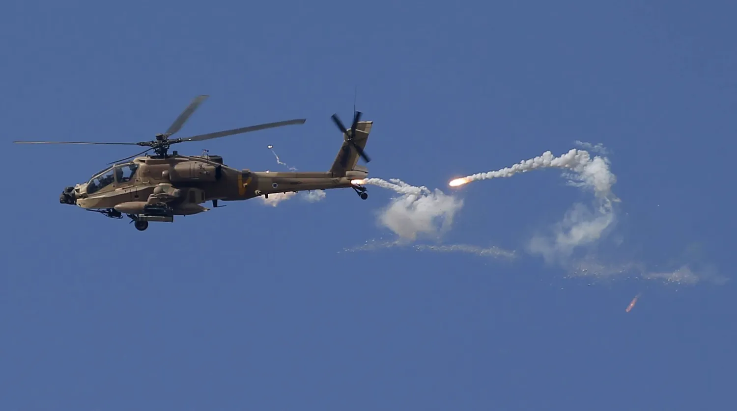An Apache attack helicopter from Israel's military fires during an Israeli army raid in the West Bank city of Jenin, 19 June 2023. EPA/ALAA BADARNEH