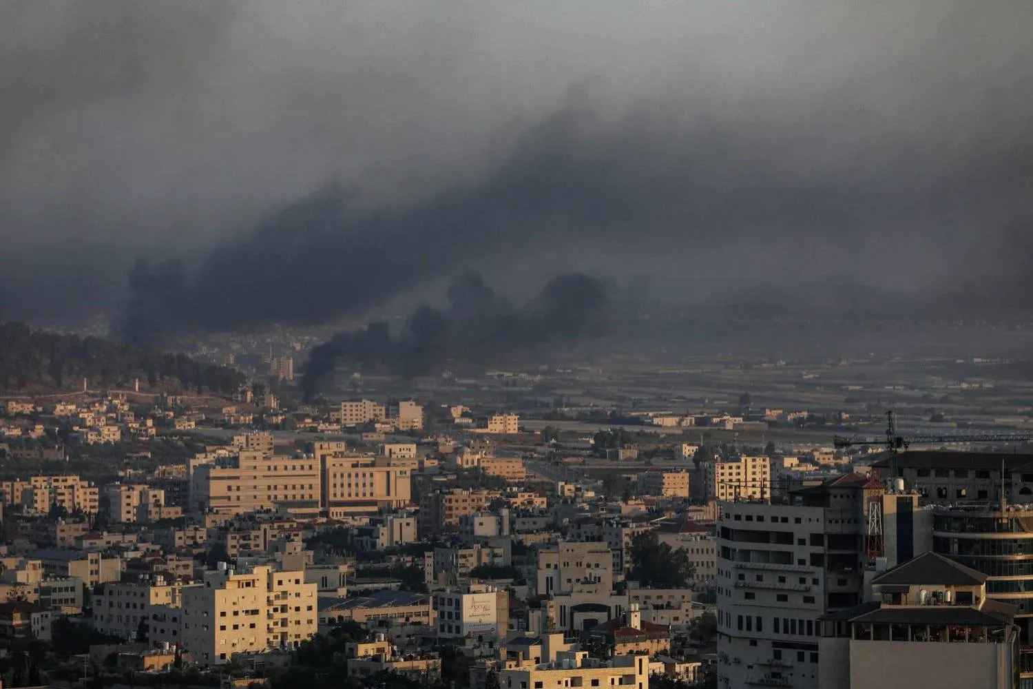 تصاعد الدخان فوق مدينة جنين جراء الغارات الإسرائيلية صباح اليوم (د.ب.أ)
