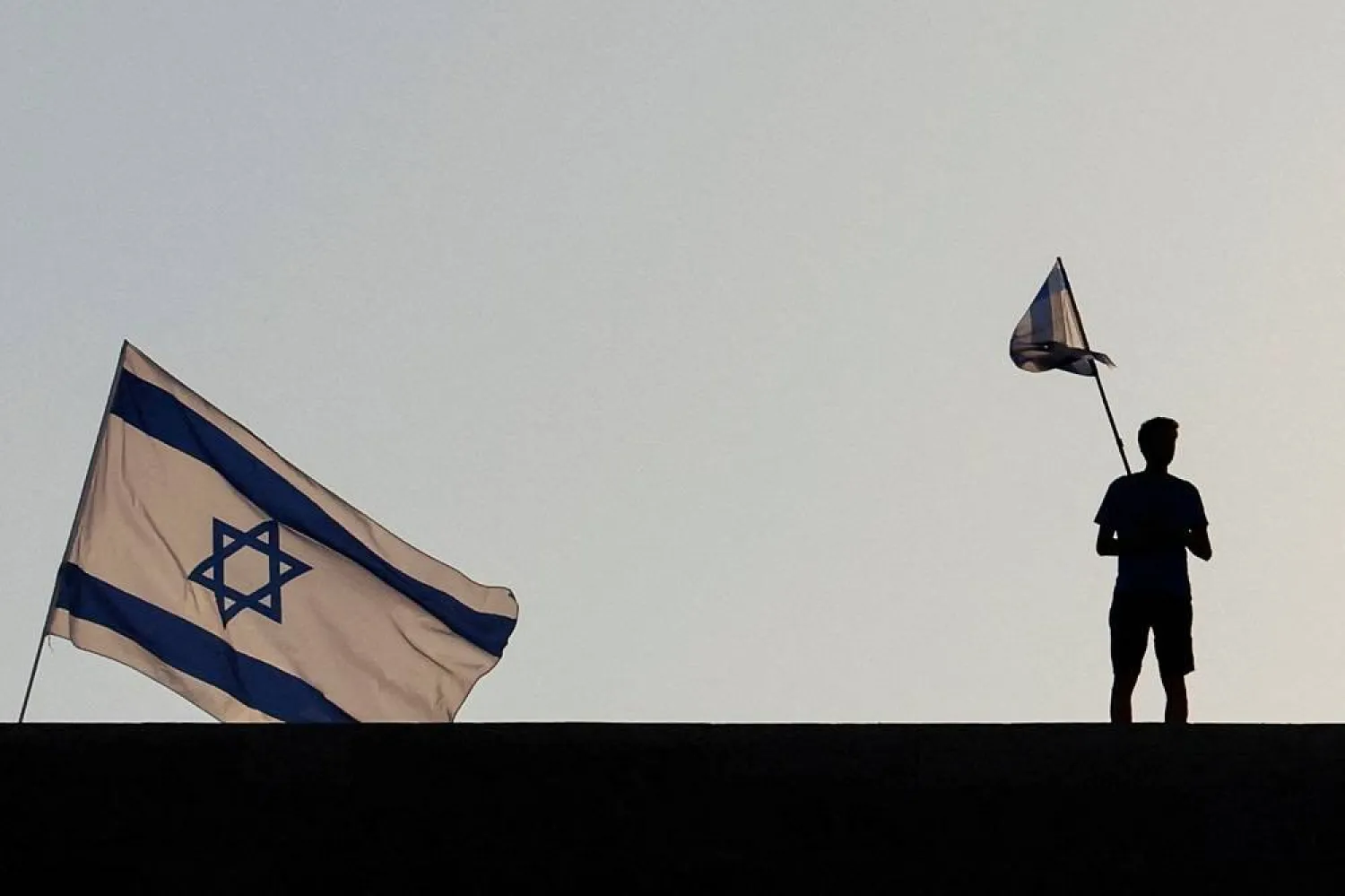  A person holds a flag during a demonstration at Ben Gurion International Airport as a response to Israeli Prime Minister Benjamin Netanyahu and his nationalist coalition government's judicial overhaul, in Lod, Israel July 3, 2023. (Reuters)