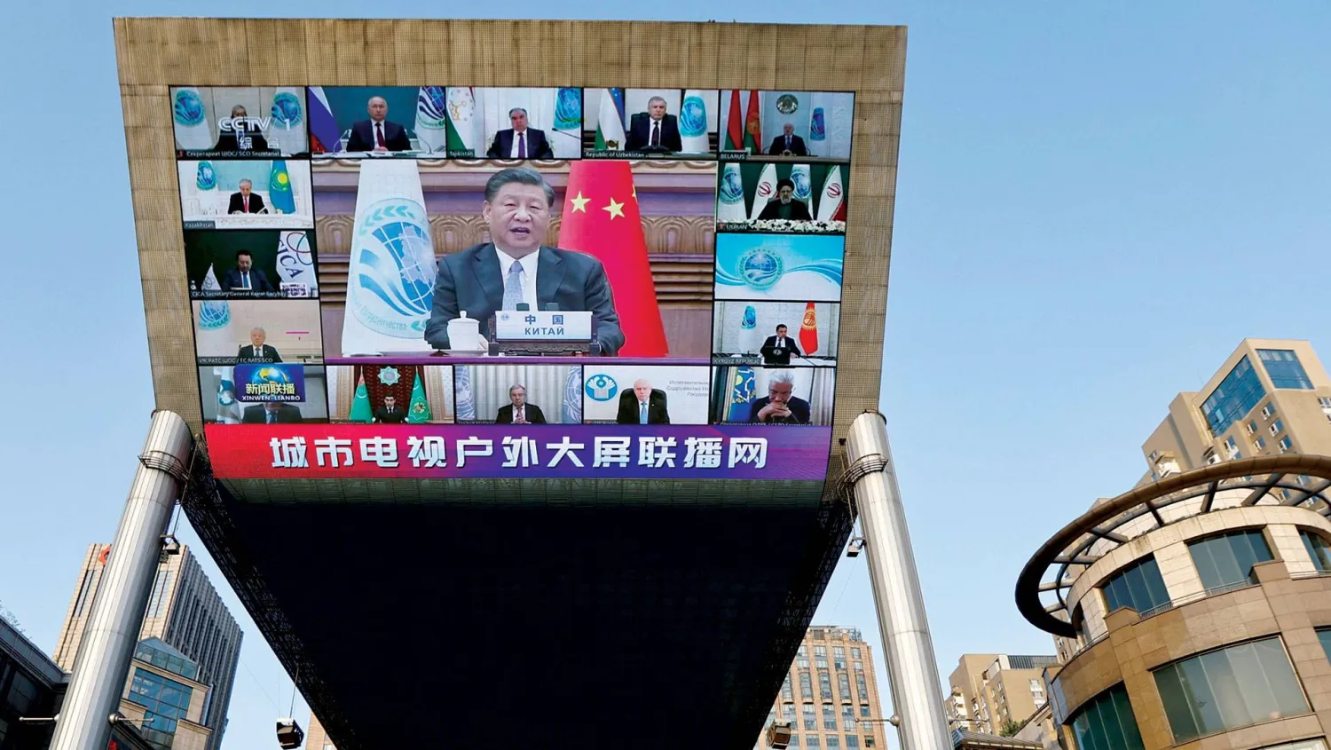 تغطية إخبارية لقمة شنغهاي الافتراضية على شاشة ضخمة في بكين أمس (رويترز)