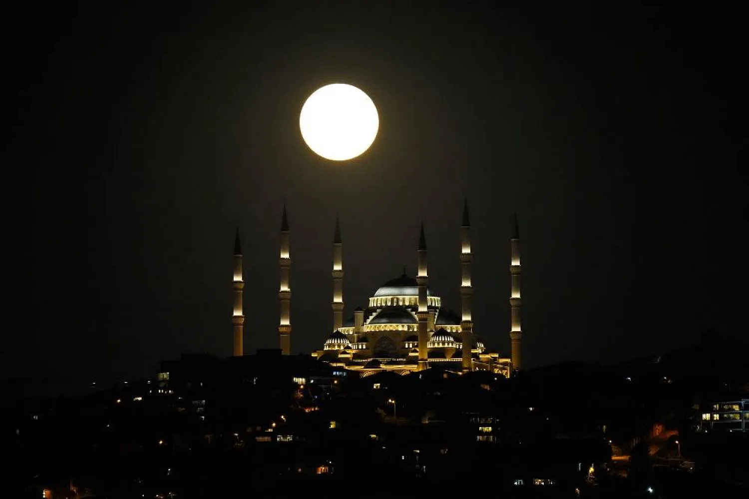 A full moon rises behind Camlica mosque in Istanbul, Türkiye, Monday, July 3, 2023. (AP)
