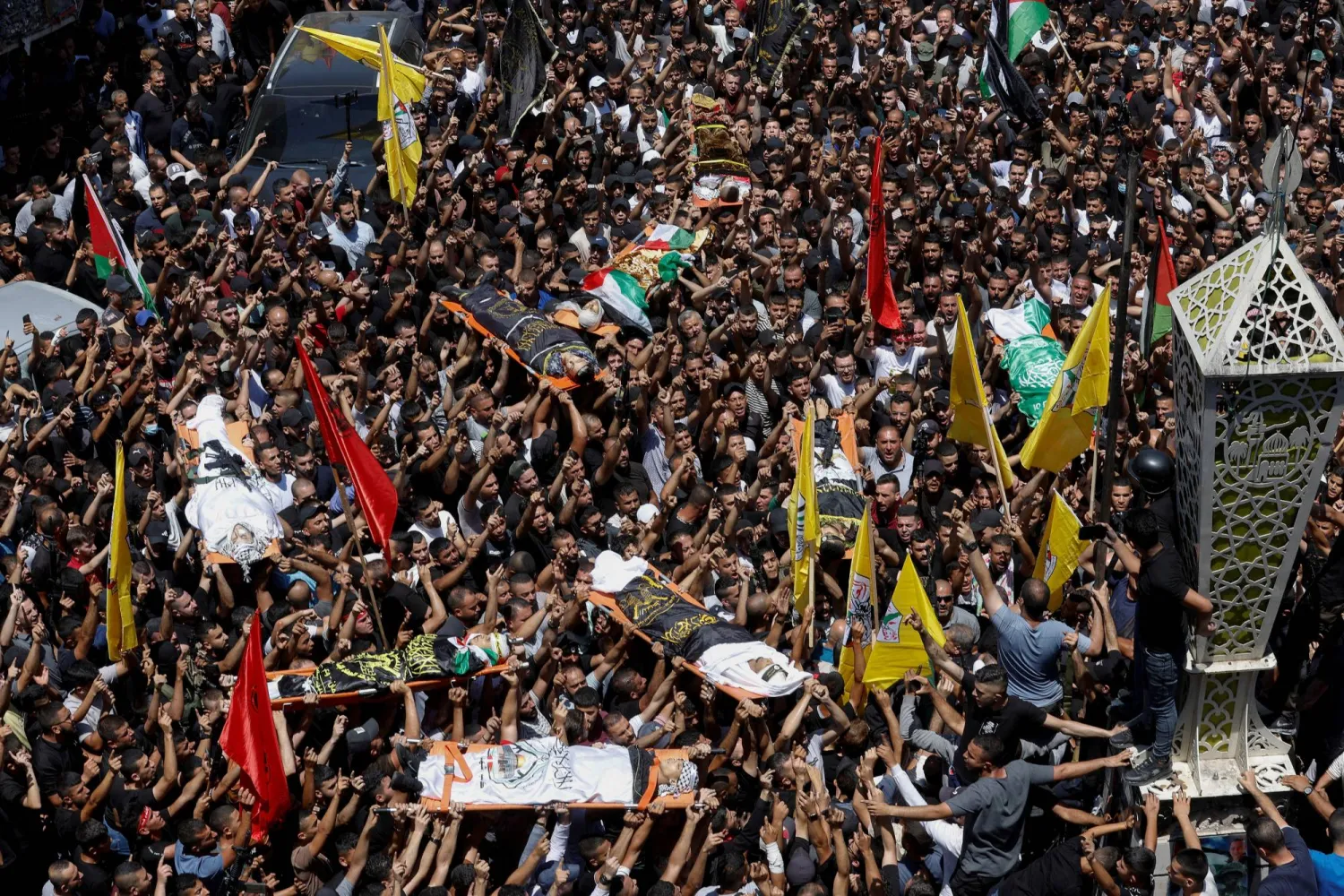 فلسطينيون خلال تشييع جثامين قتلى العملية التي نفذتها القوات الإسرائيلية في مدينة جنين (رويترز)