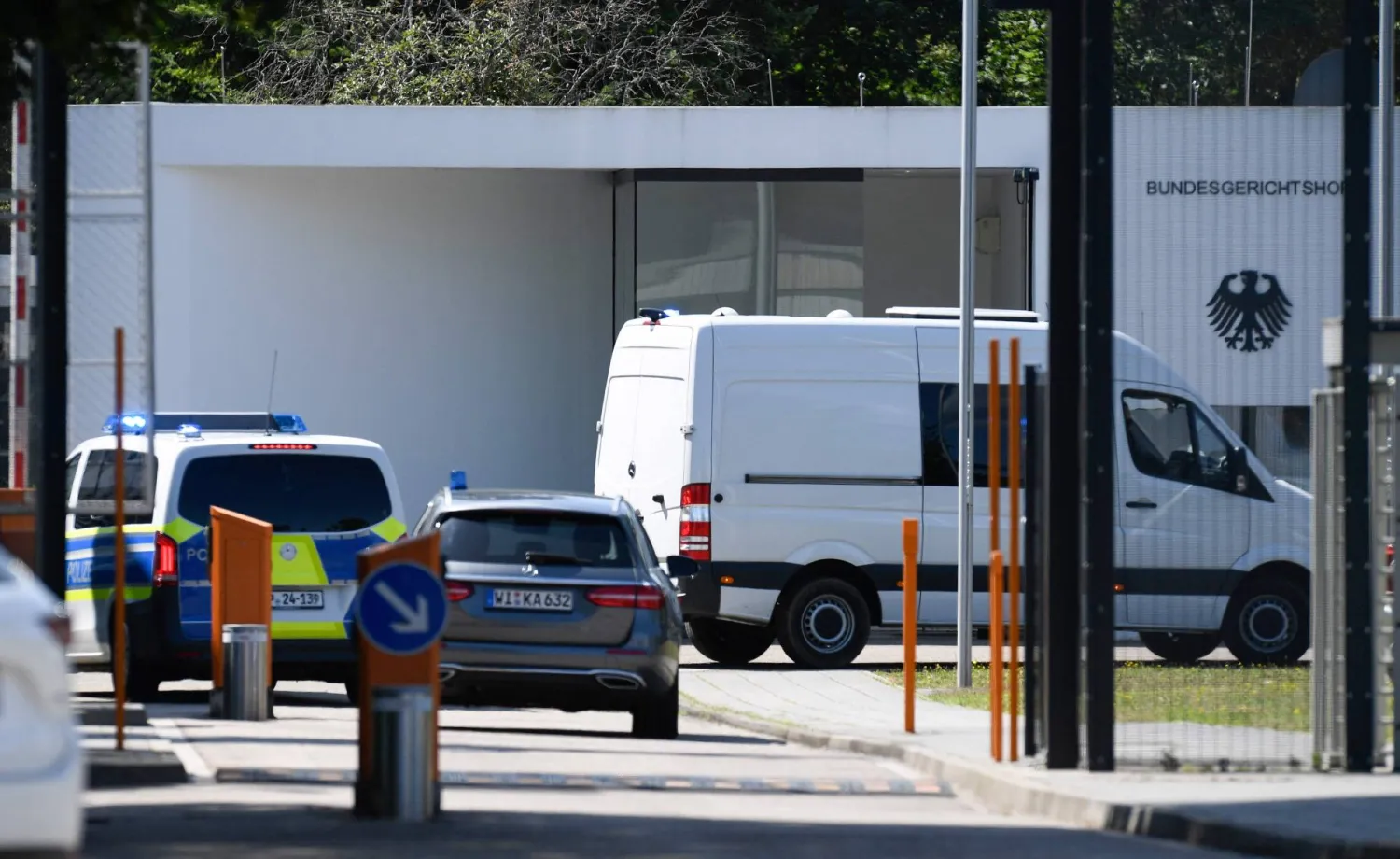 سيارات الشرطة التي يُعتقد بأنها نقلت الرجال المعتقلين إلى محكمة العدل الفيدرالية في كارلسروه بجنوب ألمانيا الخميس (أ.ف.ب)