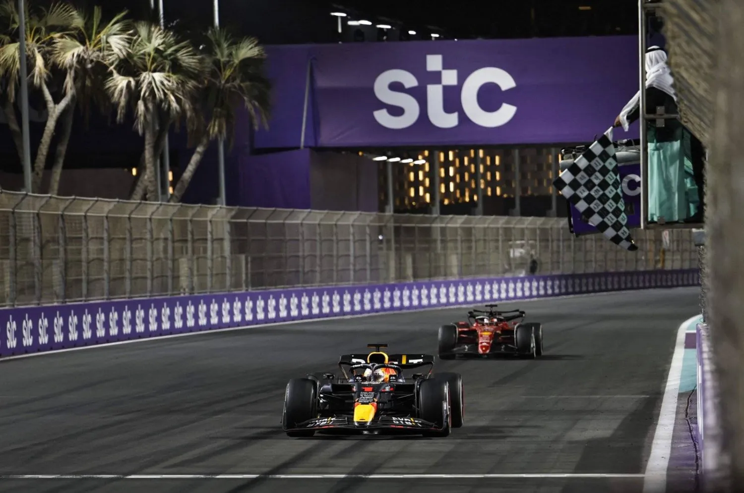 Red Bull's Dutch driver Max Verstappen (foreground) crosses the start/finish line to win the 2022 Saudi Arabia Formula One Grand Prix at the Jeddah Corniche Circuit, March 27, 2022. (AFP Photo)