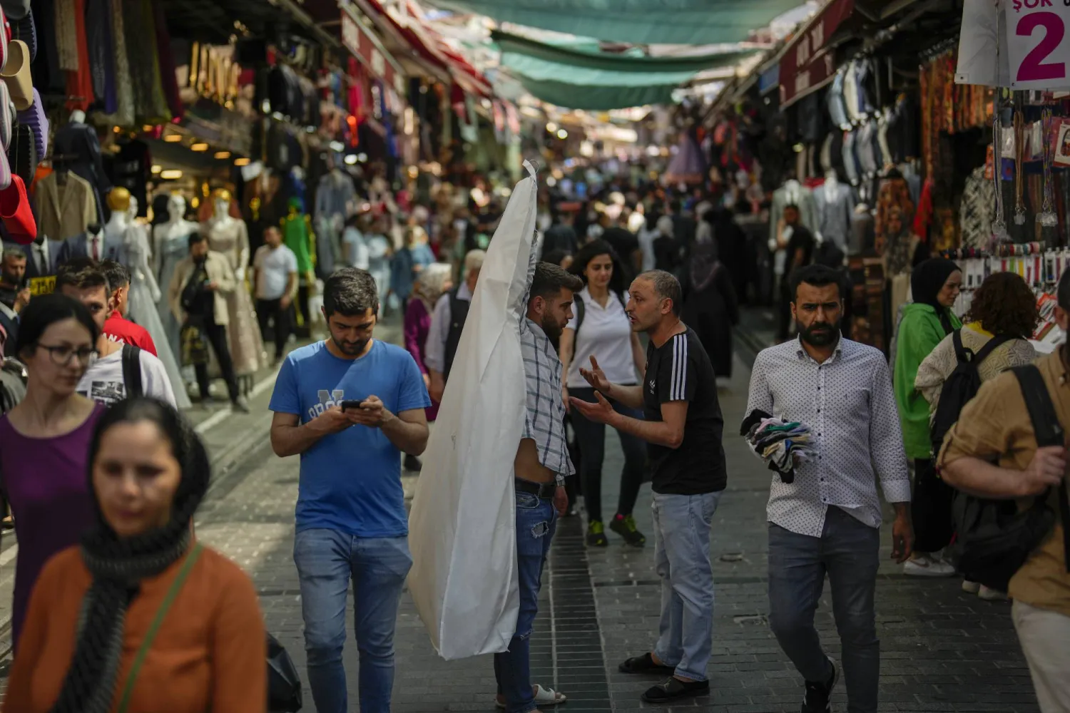 الناس يسيرون على طول سوق شوارع في منطقة إمينونو التجارية في إسطنبول بتركيا... زادت ضريبة القيمة المضافة نقطتين مئويتين في فئتين (أ.ب)