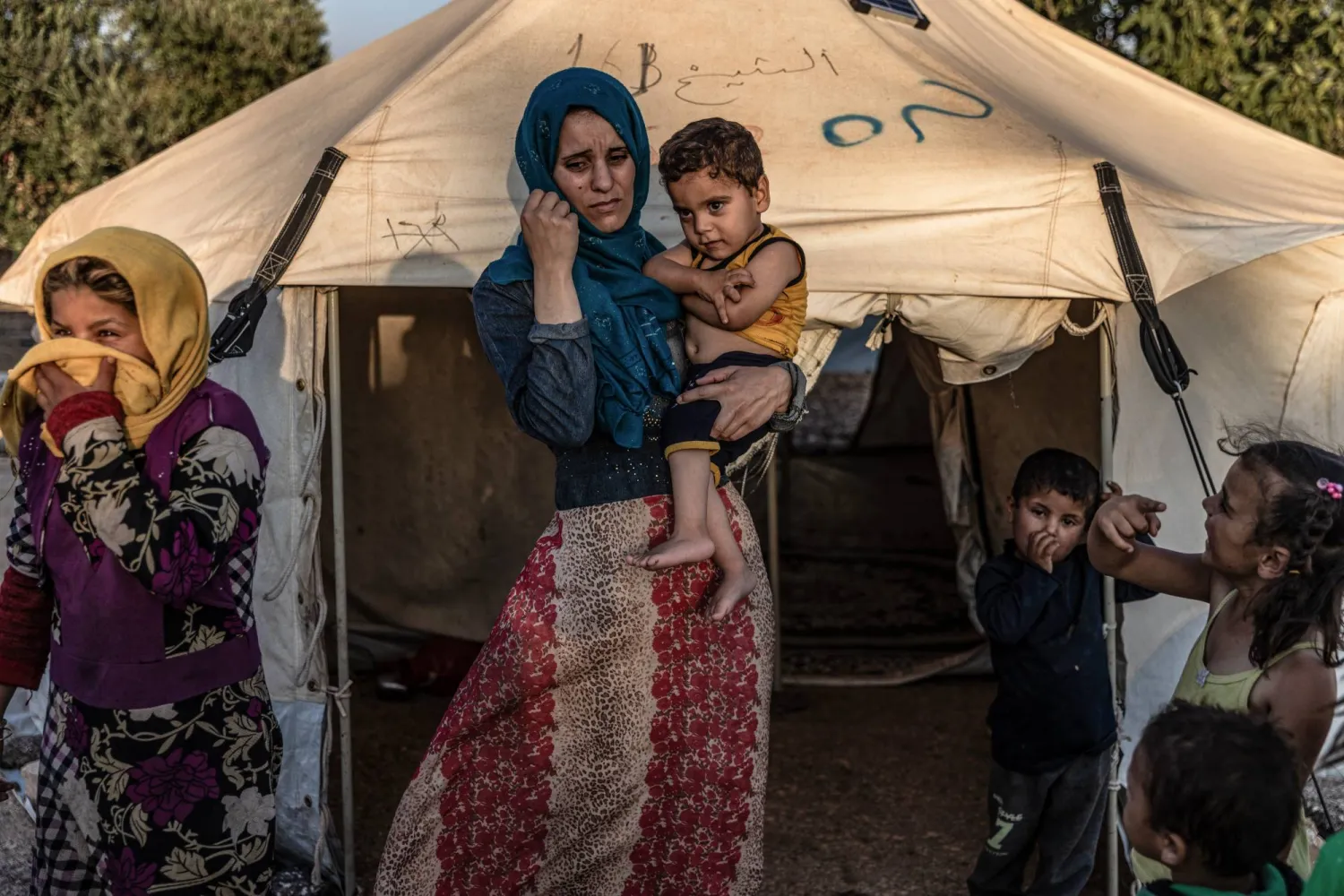 امرأة تحمل طفلها المصاب بالشلل الذي أصيب في الزلزال الأخير (د.ب.أ)