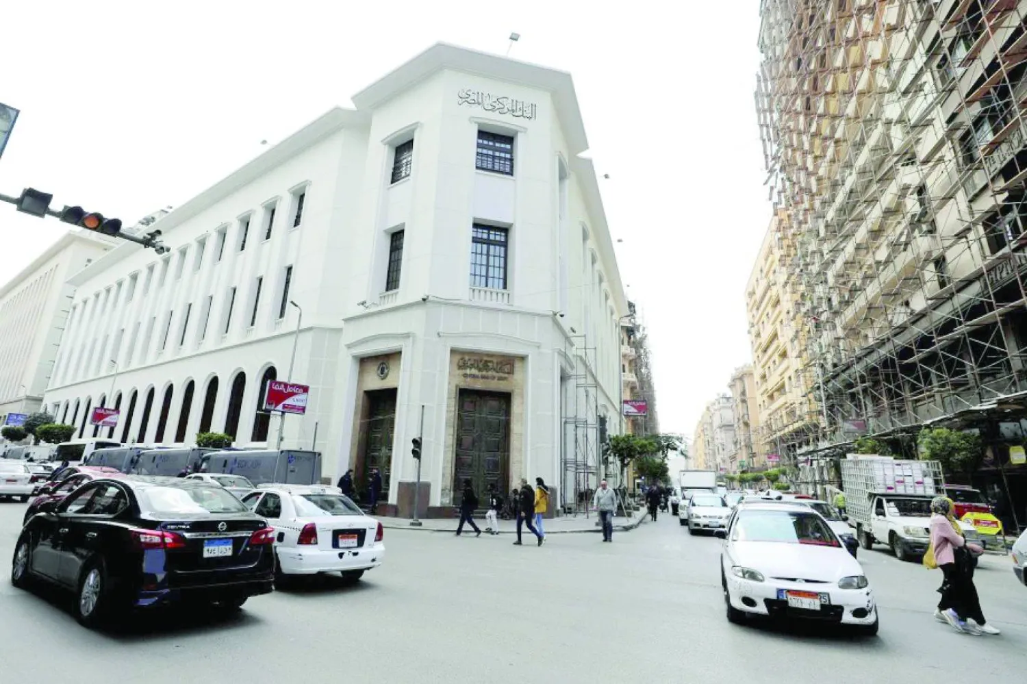 مارة وسيارات أمام مقر البنك المركزي المصري في القاهرة (رويترز)