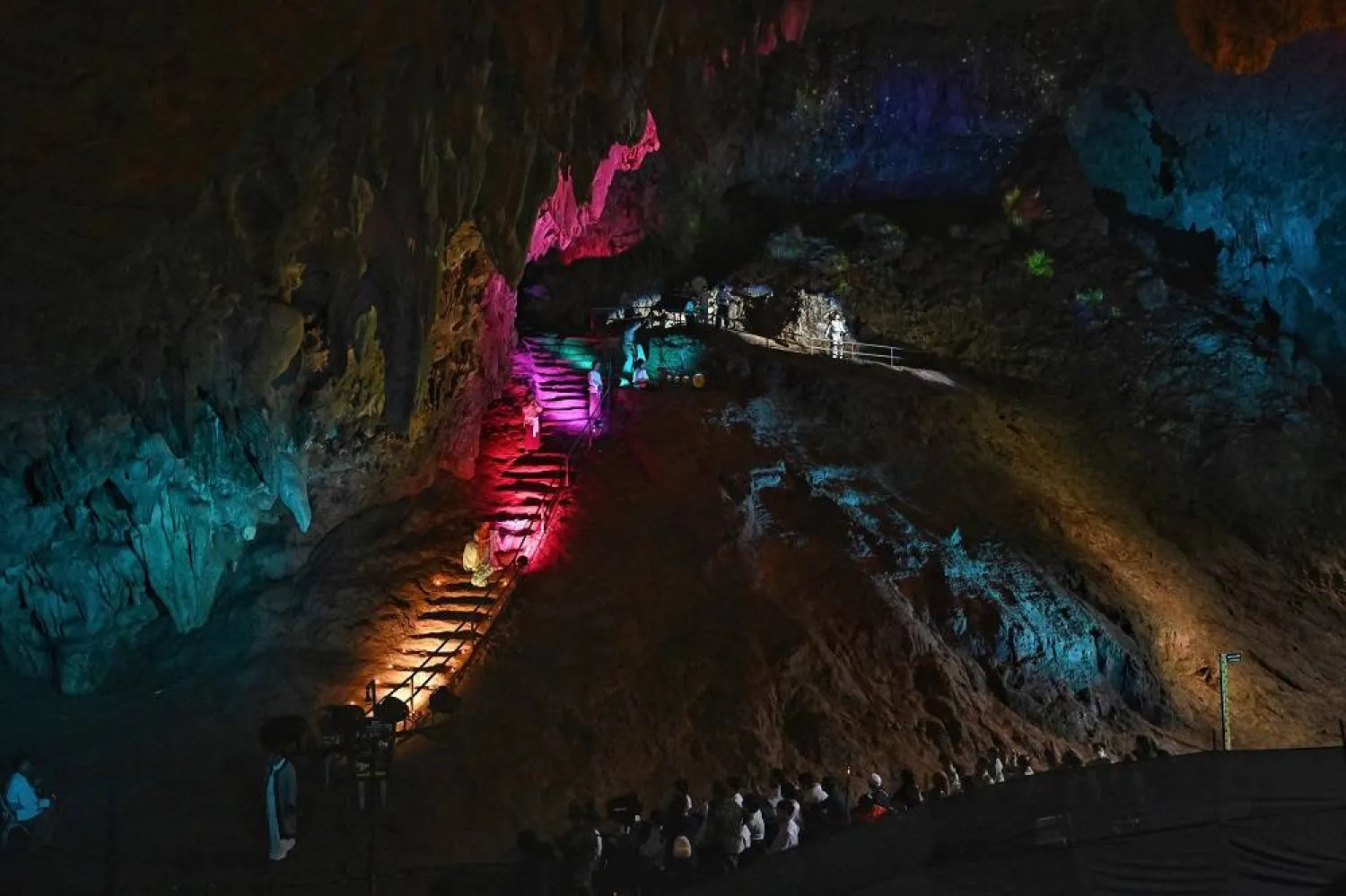Traditional performers and lights are seen inside the Tham Luang Cave in Mae Sai district in the northern province of Chiang Rai on July 10, 2023, during an event to mark the five-year anniversary of the "Wild Boars" youth football team's rescue from inside the flooded cave. (AFP)