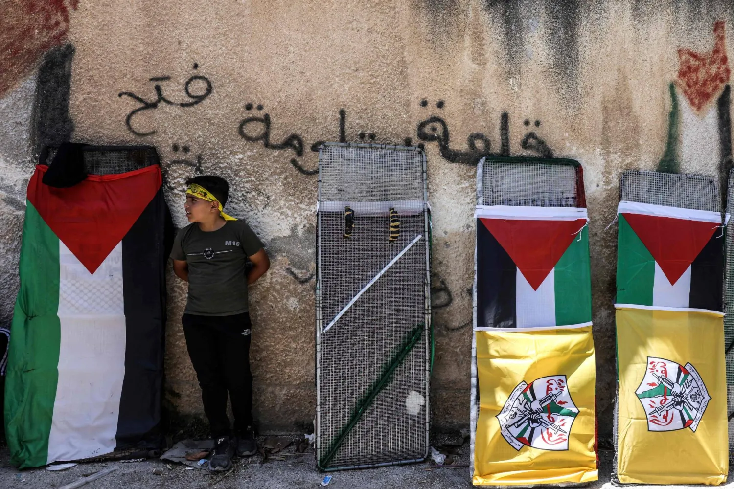 طفل يقف لالتقاط صورة له قبل مظاهرة ضد مصادرة إسرائيل أراضي قرية كفر قدوم في الضفة (أ.ف.ب)