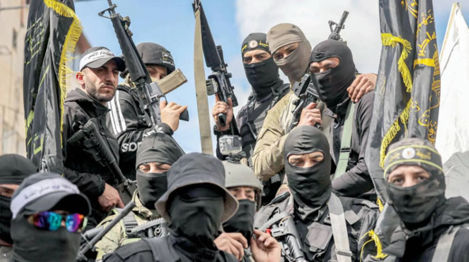 مسلحون فلسطينيون خلال جنازة قتلى هجوم الجيش الإسرائيلي على مخيم جنين (أ.ف.ب) 