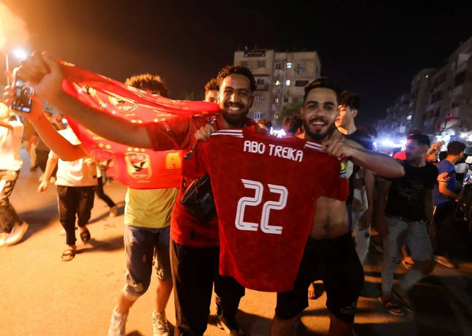 Al-Ahly fans celebrate as they display a shirt with the name of former player Mohamed Abo Treika after their team won the CAF Champions League match against Wydad Casablanca in Cairo's Mokattam district, Egypt June 11, 2023. (Reuters) 