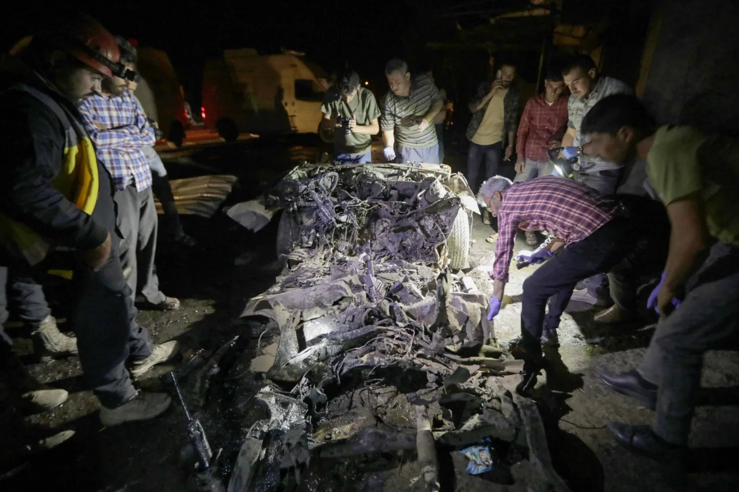 الناس يتجمعون حول حطام سيارة بعد انفجار سيارة مفخخة  الأسبوع الماضي (أ.ف.ب)