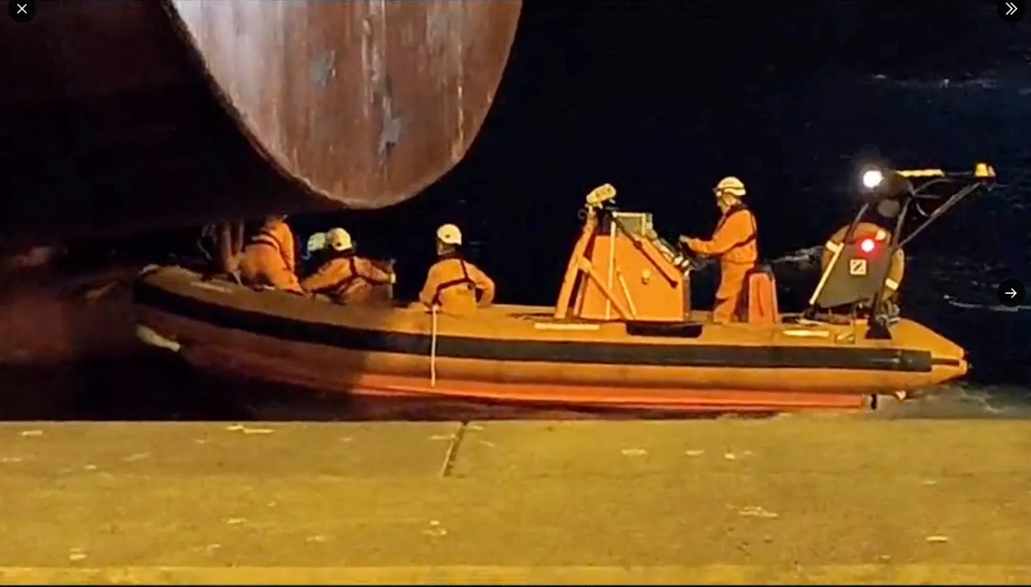 أفراد من خفر السواحل الإسباني في لاس بالماس دي غران كناريا بإسبانيا ينقذون اثنين من المهاجرين النيجيريين اللذين اختبآ على دفة سفينة وصلت إلى جزر الكناري من توغو في هذه الصورة المأخوذة من مقطع فيديو تم الحصول عليه من وسائل التواصل الاجتماعي ونُشر في 11 يوليو 2023 (رويترز)