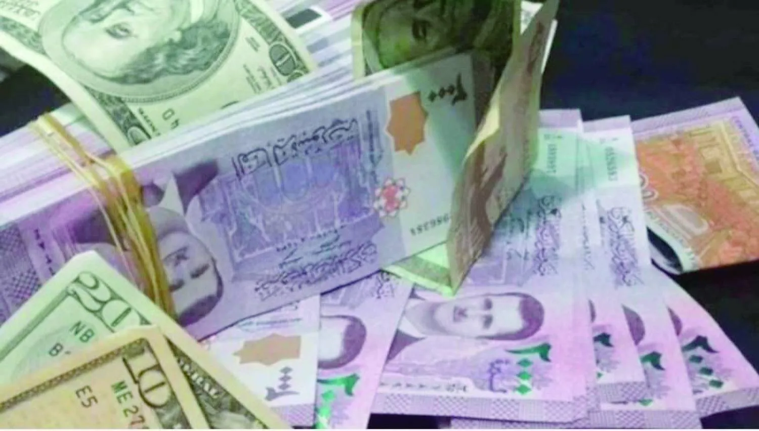 عملات من الليرة السورية والدولار (رويترز)