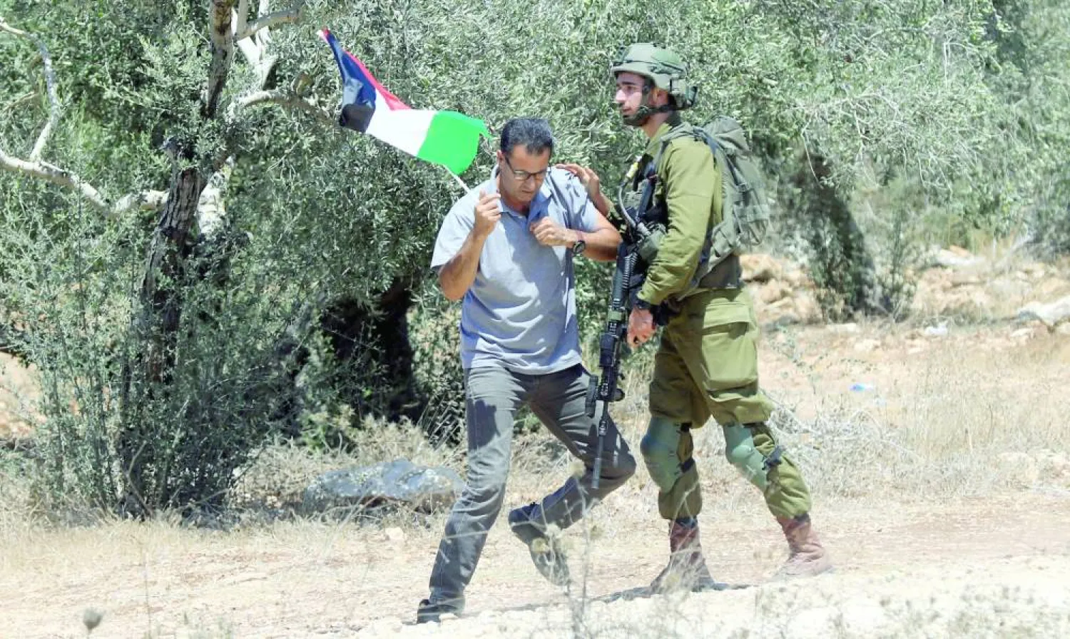 فلسطيني يشتبك مع جندي إسرائيلي خلال مظاهرة ضد التوسع الاستيطاني في قرية بيت ليد قرب طولكرم بالضفة (أرشيفية - إ.ب.أ)