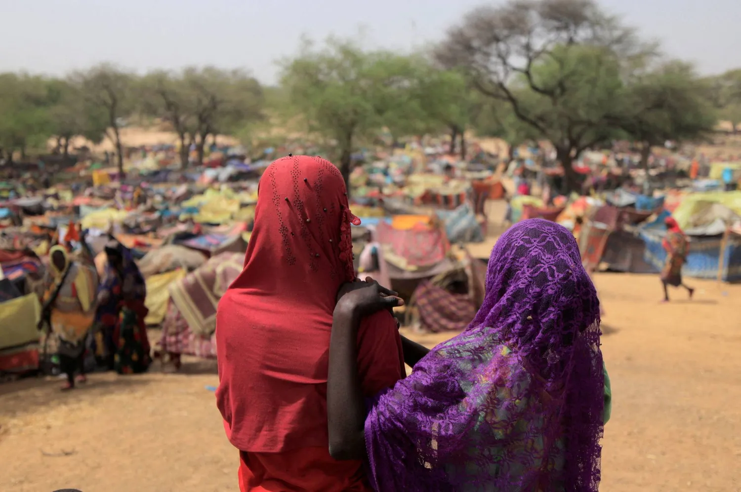 FILE PHOTO: Sudanese girls who fled the conflict in Sudan's Darfur region, and were previously internally displaced in Sudan, look at makeshift shelters near the border between Sudan and Chad, while taking refuge in Borota, Chad May 13, 2023. REUTERS/Zohra Bensemra/File Photo