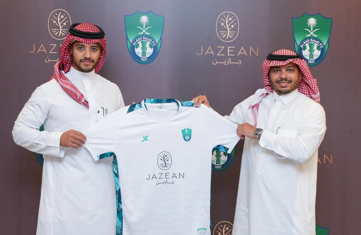 خليفة خلال إهدائه محمد زيني قميصاً تذكارياً للأهلي بعد توقيع العقد (الشرق الأوسط)