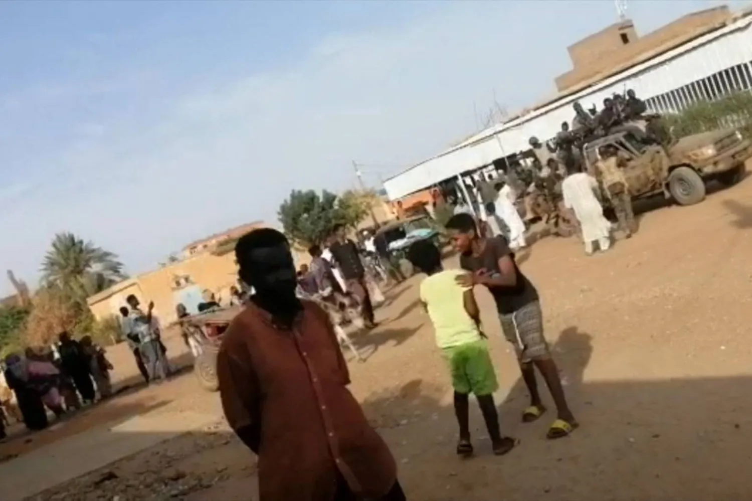 لقطة من فيديو يظهر أطفالاً وجنوداً من القوات المسلحة السودانية يقودون مركبات عسكرية في أحد شوارع أمدرمان الخميس (أ.ف.ب)