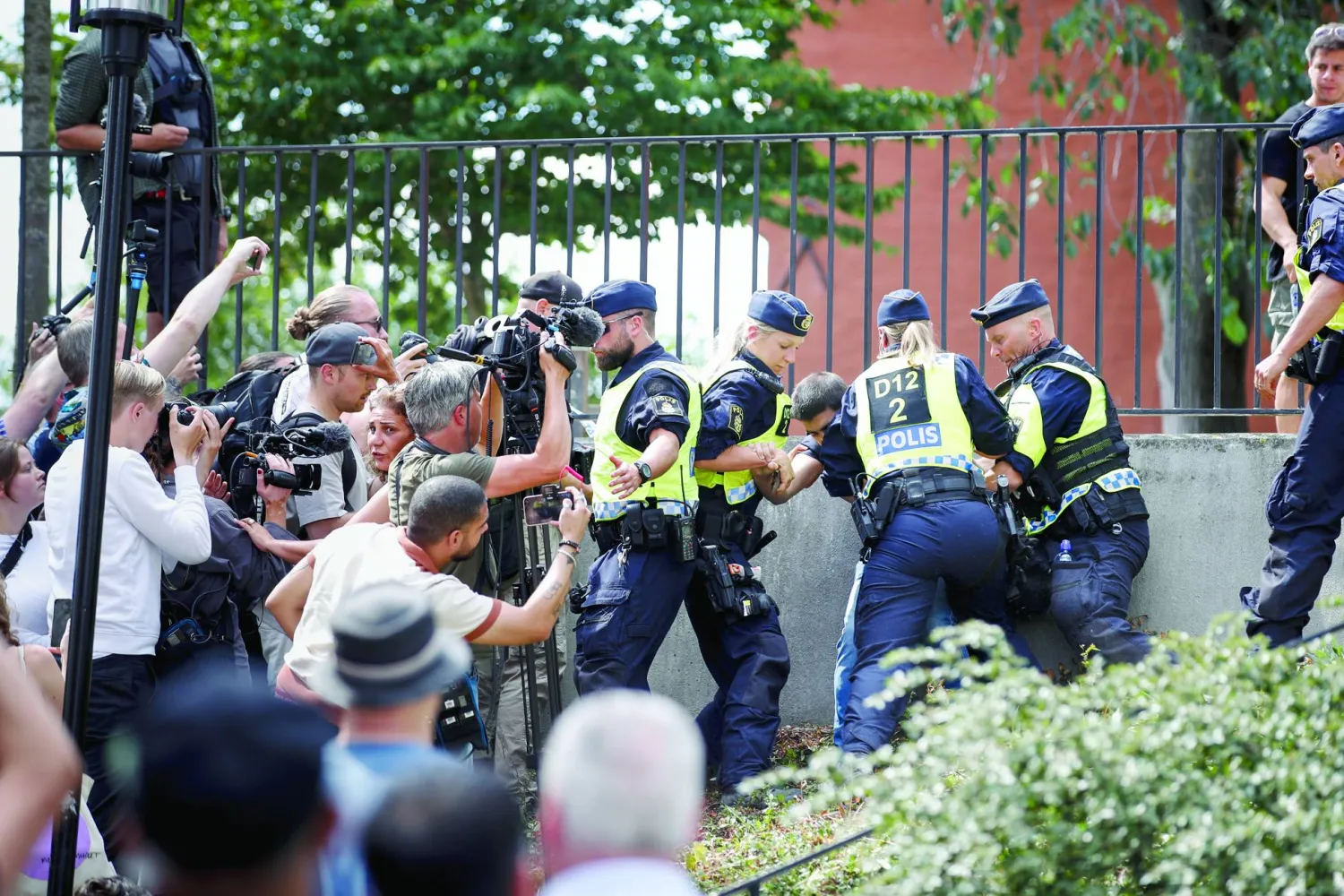 Police officers intervene at the scene where a man set a copy of the Quran on fire outside a mosque in Stockholm, Sweden, June 28, 2023. EPA/STEFAN JERREVANG  