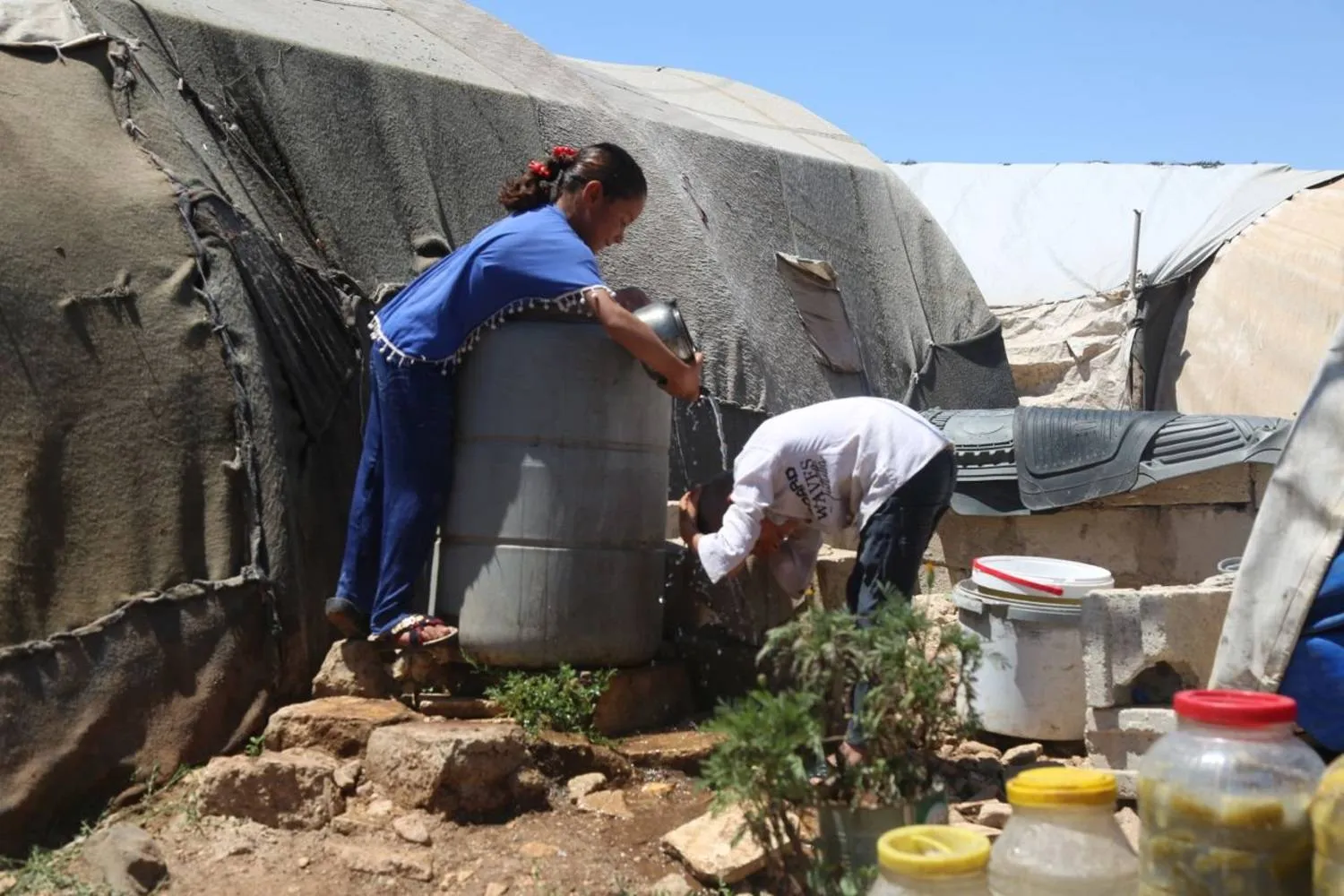 Refugees try to cool off during the heatwave. (Syrian Civil Defense) 
