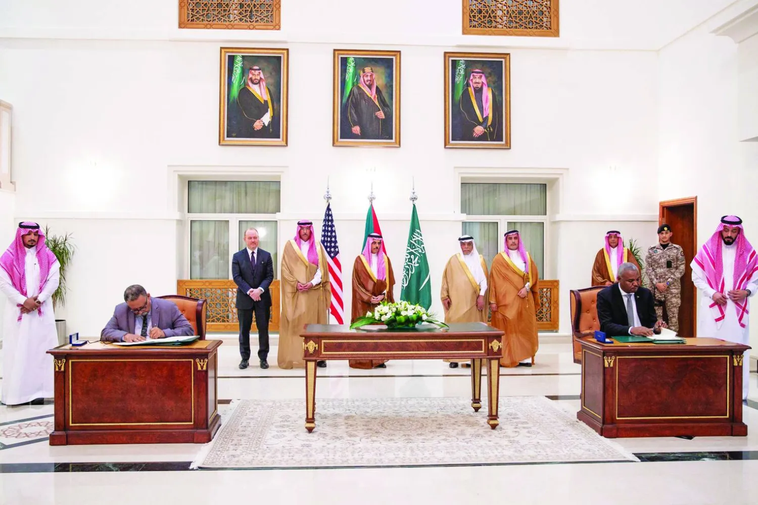 وزير الخارجية السعودي إلى جانب ممثلين عن طرفَي النزاع السوداني خلال توقيع اتفاق جدة في 21 مارس (رويترز)