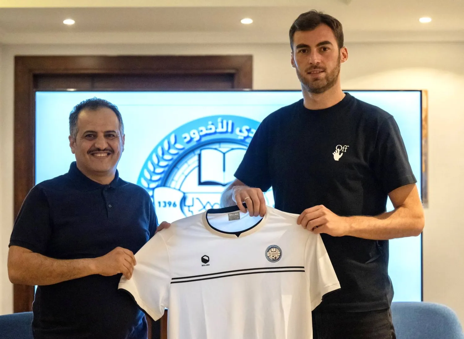 الجورجي سلومون يتسلم قميص «الأخدود» من حسن مرزوق بعد التوقيع (نادي الأخدود)