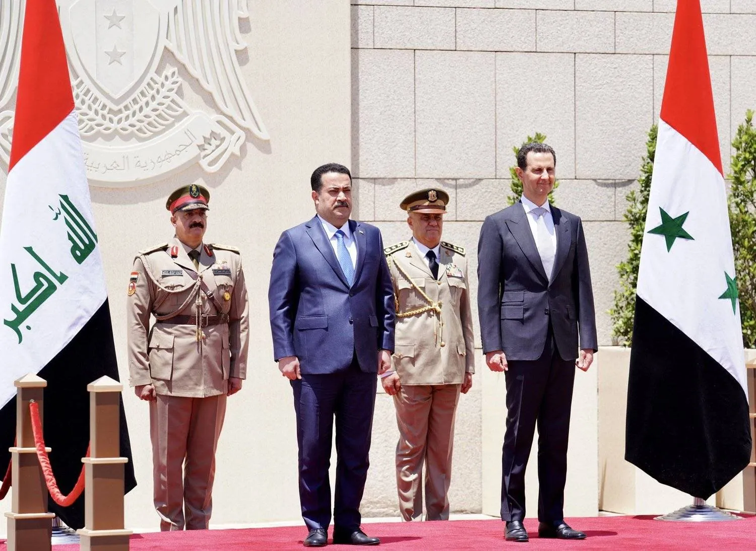 A handout picture released by the Iraqi Prime Minister's Media Office shows Prime Minister Mohammed Shia al-Sudani (L) reviewing honor guards with Syria's President Bashar al-Assad in Damascus on July 16, 2023. (Photo by IRAQI PRIME MINISTER'S PRESS OFFICE / AFP) 