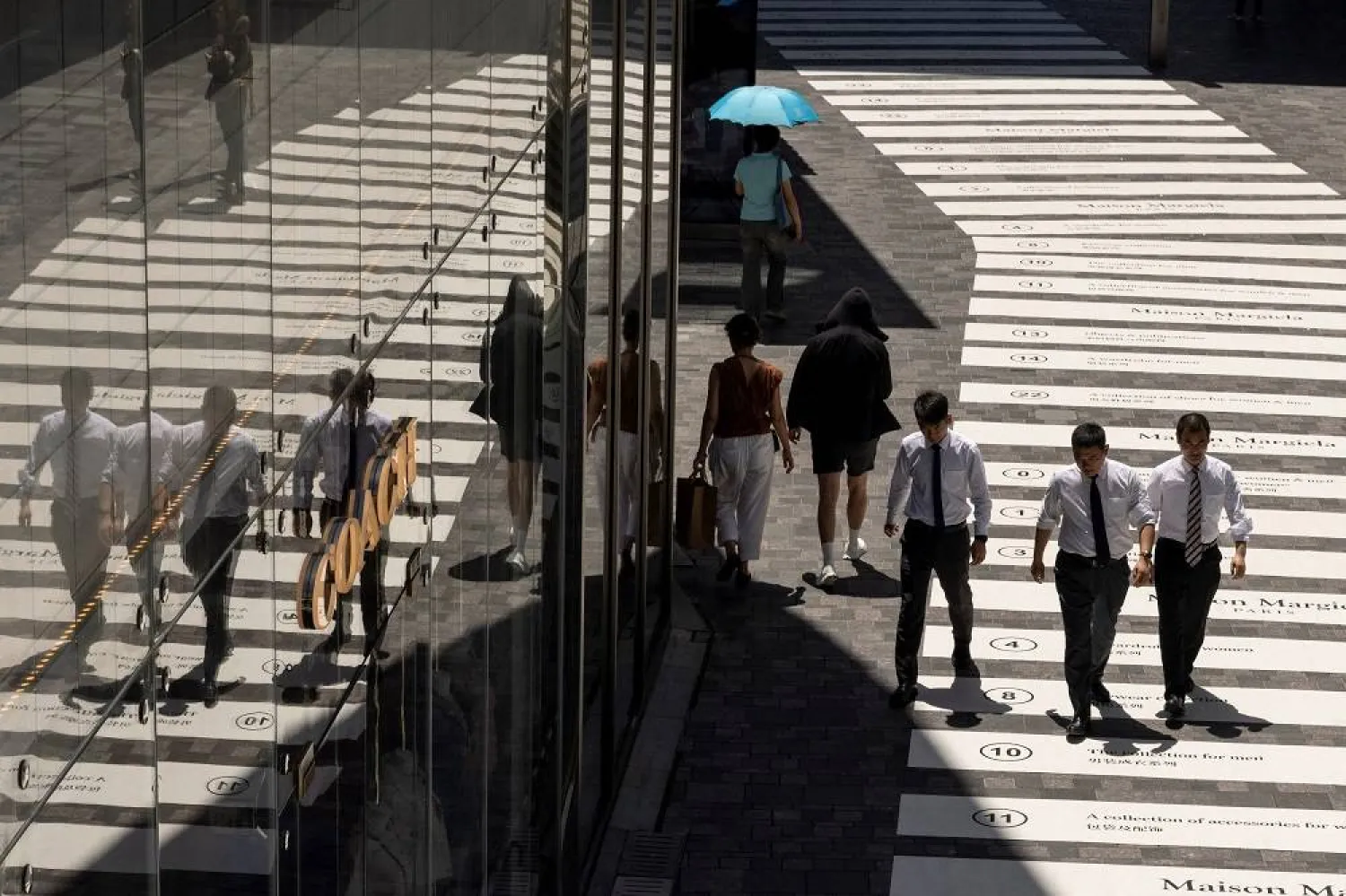 People walk in a shopping district in Beijing, China, July 14, 2023. (Reuters)
