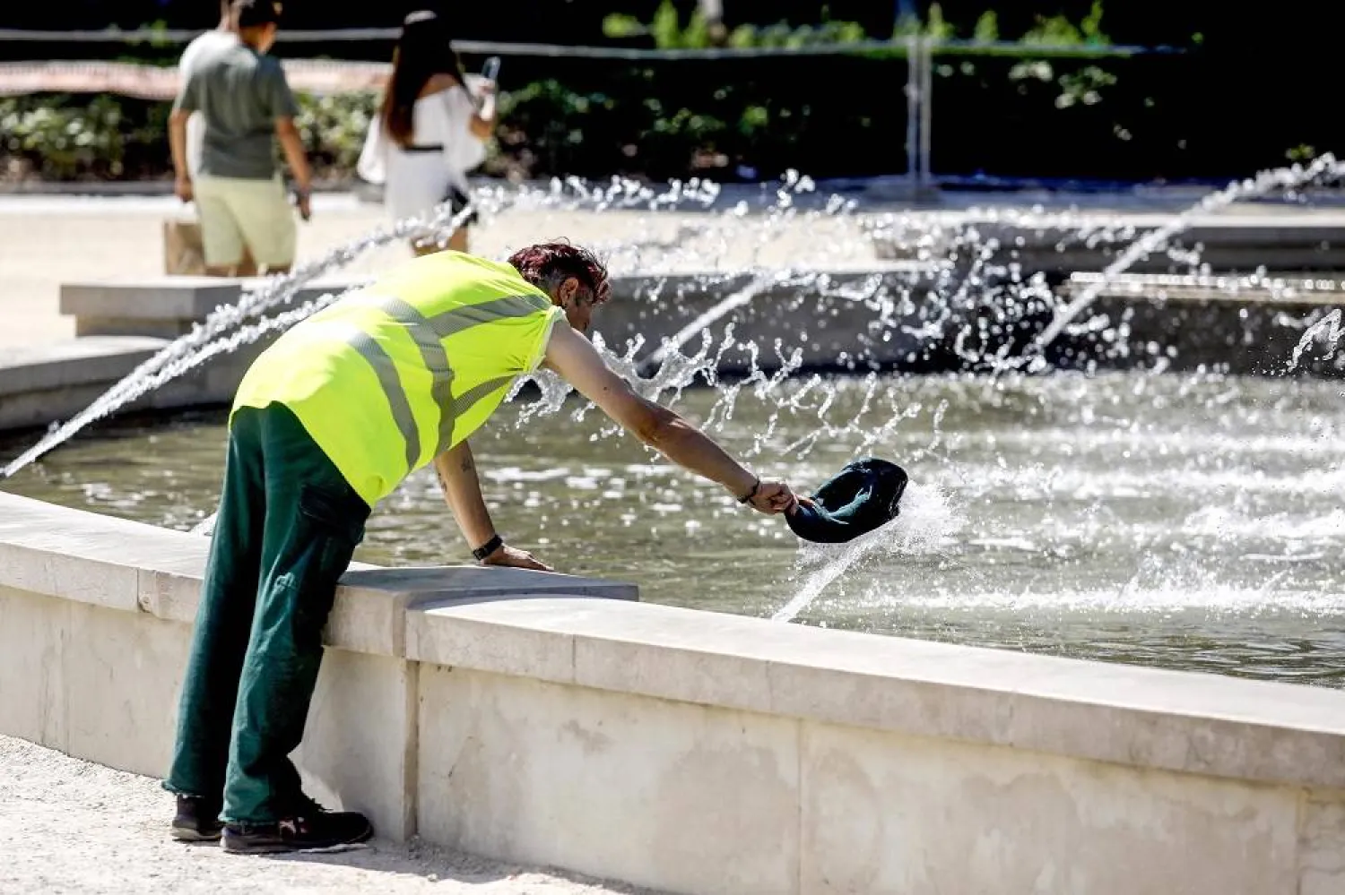 A man cools off in a fountain in Milan, Italy, 16 July 2023. (EPA)